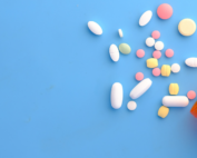 Frasco com remédios coloridos espalhados, ilustrando o gerenciamento de risco no transporte de medicamentos.