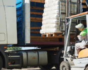 Caminhão recebendo mercadorias com empilhadeira mostra o problema do excesso de carga.