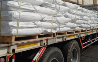 Caminhão carregado com sacos brancos representa as rotas de fertilizantes no Brasil.
