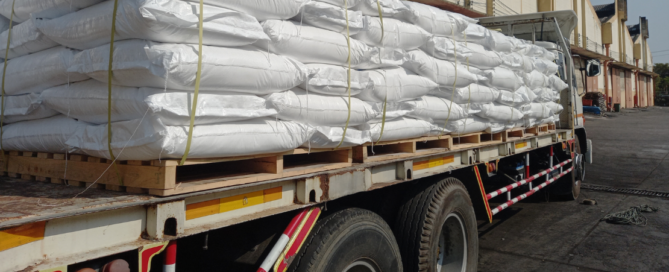 Caminhão carregado com sacos brancos representa as rotas de fertilizantes no Brasil.