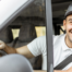 Motorista feliz dentro do caminhão mostra a importância da saúde mental na estrada.