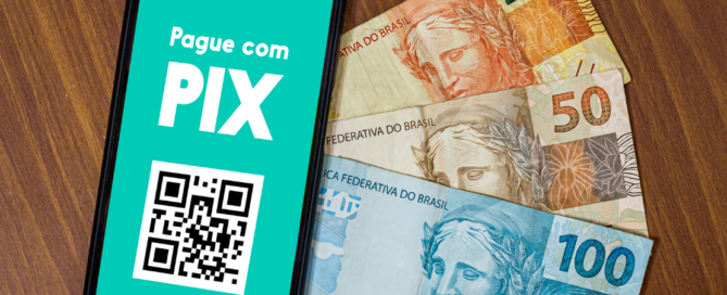 Tela do Pix no celular e notas de dinheiro ilustram possibilidade de pagar pedágio no Pix e no cartão.