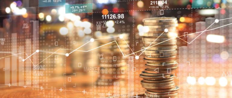 Em primeiro plano, tem várias moedas douradas empilhadas. Além disso, vários gráficos em linhas estão sobrepondo a imagem, mostrando os altos e baixos do ciclo financeiro e do fluxo de caixa.