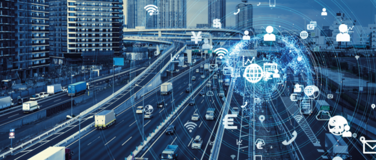 A imagem mostra, em segundo plano, várias pistas em uma cidade grande com diversos veículos circulando ao mesmo tempo, inclusive caminhões. Em primeiro plano, vários símbolos estão sobrepostos, como o sinal de wi-fi, e-mail, telefone, aparelho de celular etc., representando as tecnologias para a segurança do transporte rodoviário de cargas.