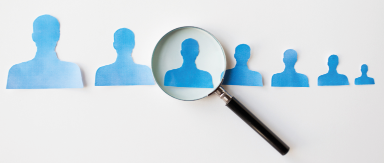 A imagem mostra o perfil de 7 bonecos na cor azul. O tamanho deles começa maior ao lado esquerdo e vai diminuindo conforme se aproxima do lado direito. Uma lupa está sobre o terceiro desenho, representando os riscos na hora da contratação dos motoristas.
