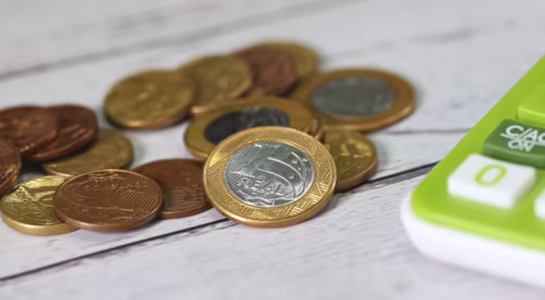 moedas-ao-lado-de-uma-calculadora
