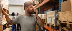 Um funcionário de armazém coordenando a movimentação de um palete de entregas, agilizando o fluxo de mercadorias em uma operação de cross docking.