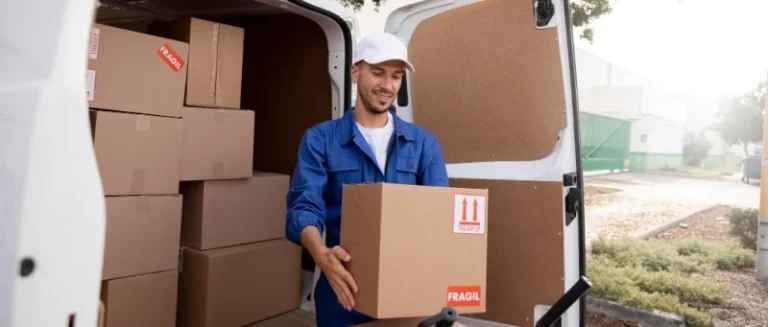 Um motorista de caminhão descarregando uma caixa de papelão, ilustrando a rotina de entregas de um profissional autônomo atuando no modelo de agregados